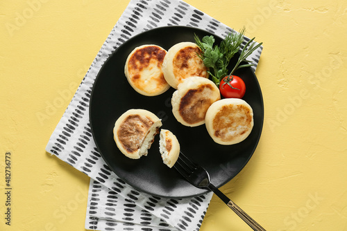 Plate with tasty cottage cheese pancakes on color background