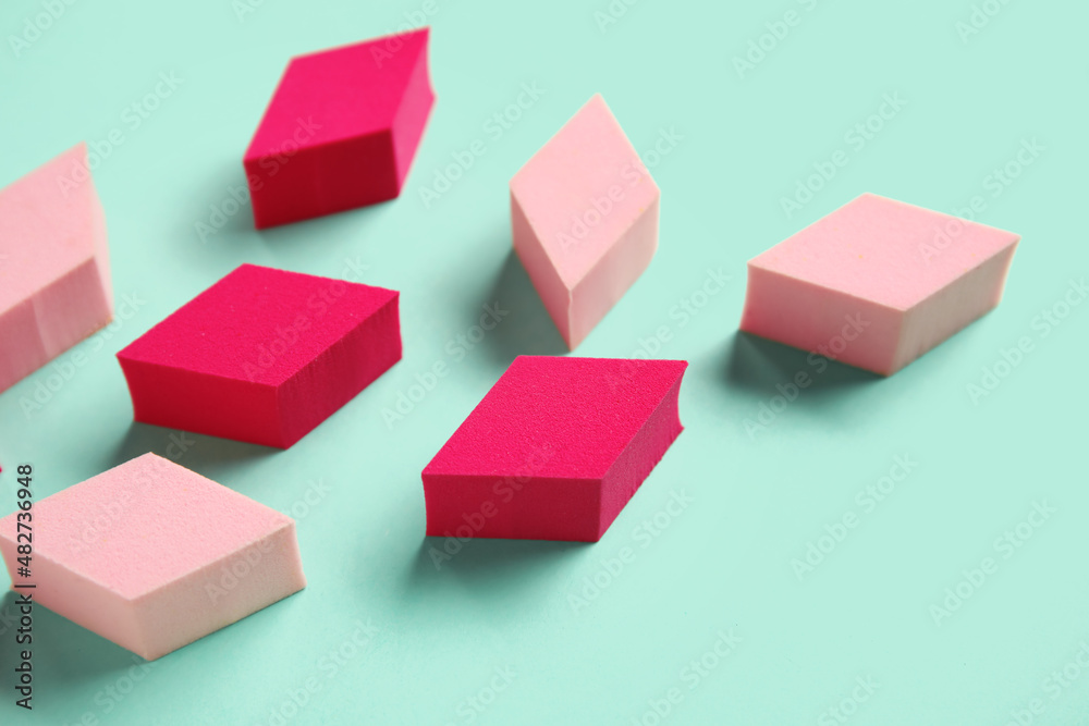 Different makeup sponges on turquoise background, closeup Different makeup sponges on turquoise background, closeup