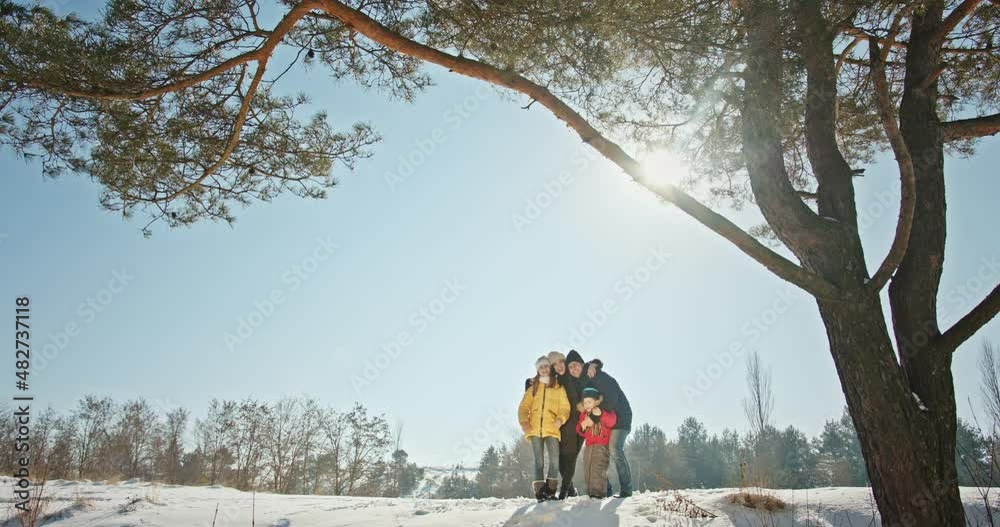 Happy family hugging together in winter woods Happy family hugging together in winter woods