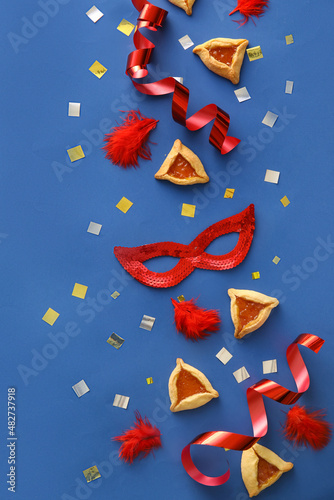 Carnival mask and Hamantaschen cookies for Purim holiday on color background photo