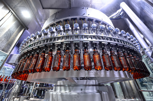 Bilde på lerret Filling plastic bottles with various drinks on an automatic filling machine
