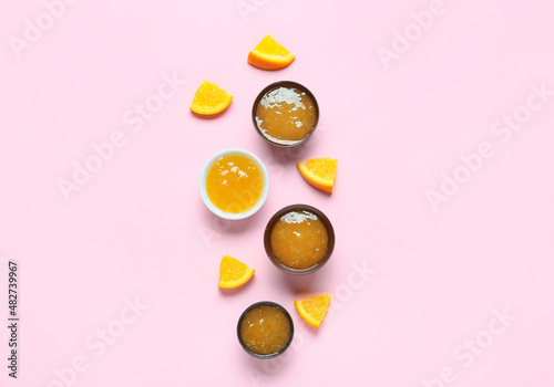 Composition with tasty orange jam on pink background