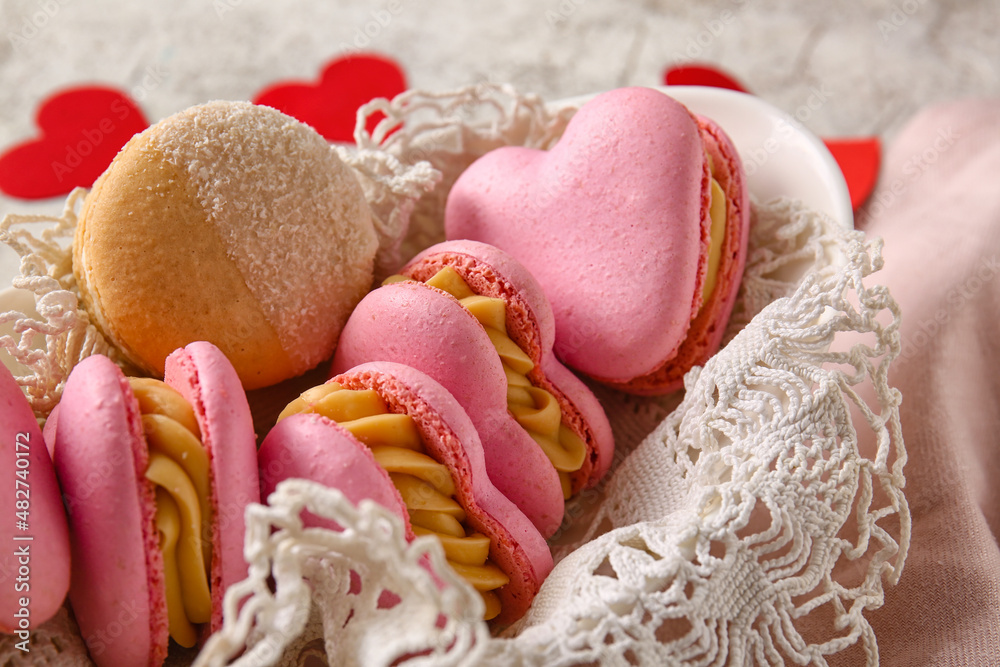 Bowl with tasty heart-shaped macaroons on light background, closeup Bowl with tasty heart-shaped macaroons on light background, closeup
