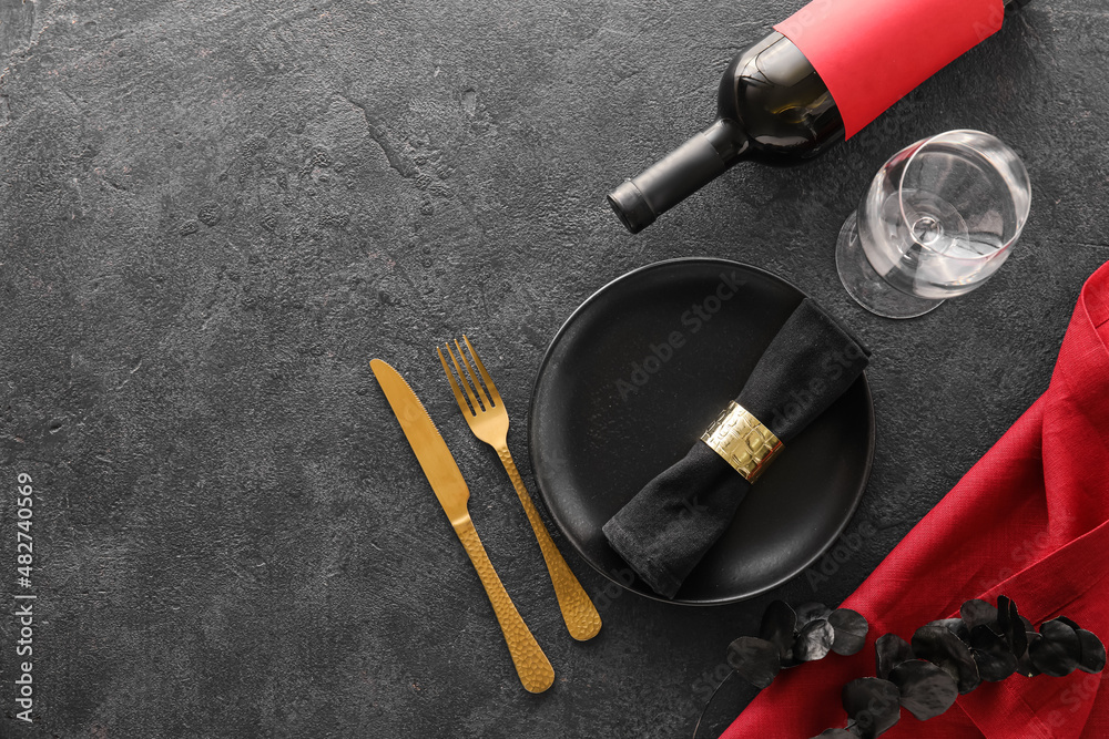 Beautiful table setting and bottle of wine on dark background Beautiful table setting and bottle of wine on dark background