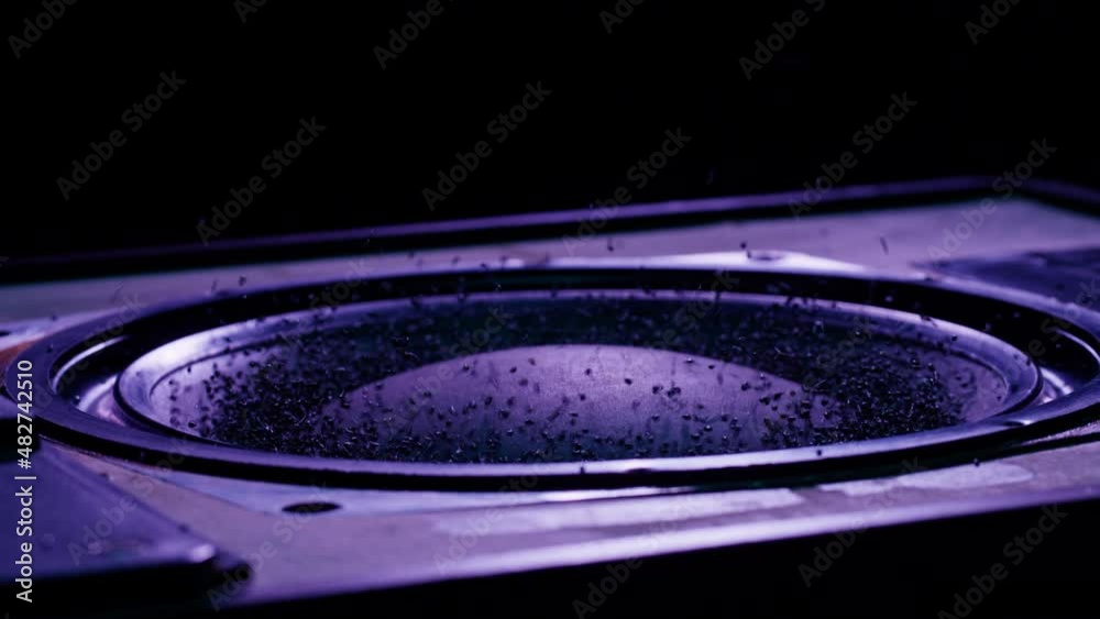 Acoustic sound system close-up, flying spices. Loud music volume macro shooting. Professional disco studio equipment subwoofer. Playback of musical stereo system, vibration.