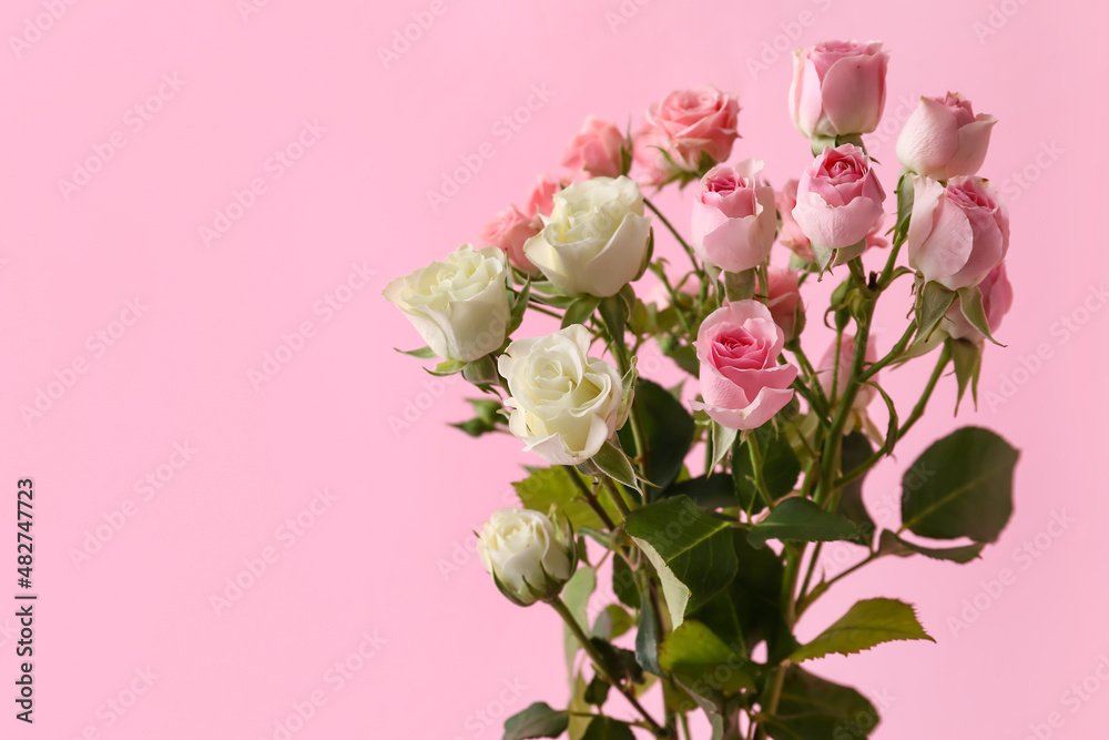 Vase with bouquet of beautiful roses on pink background