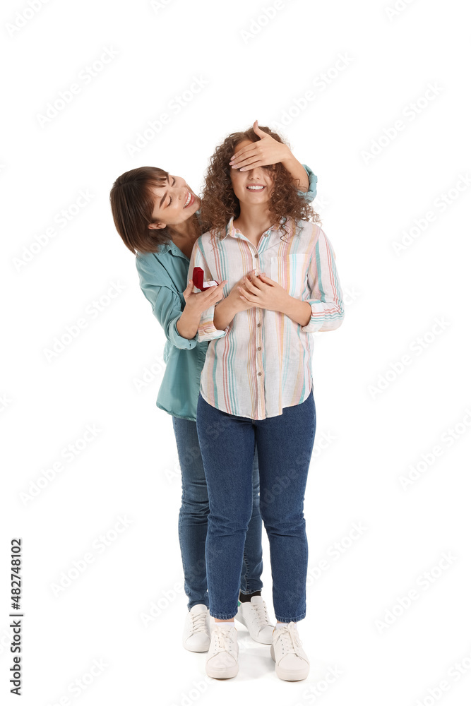 Young lesbian woman proposing to her girlfriend on white background Young lesbian woman proposing to her girlfriend on white background