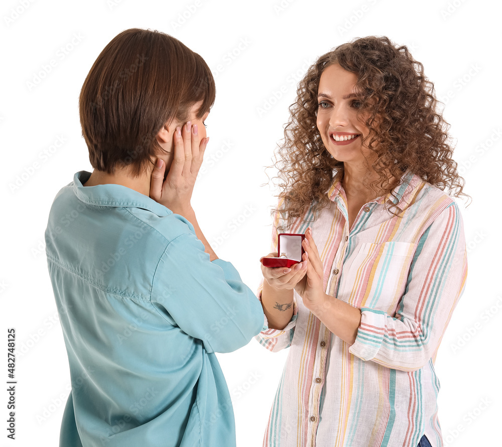 Young lesbian woman proposing to her girlfriend on white background Young lesbian woman proposing to her girlfriend on white background