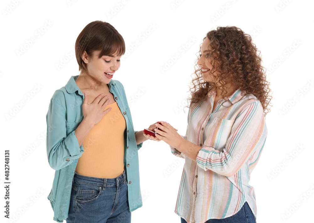 Young lesbian woman proposing to her girlfriend on white background Young lesbian woman proposing to her girlfriend on white background