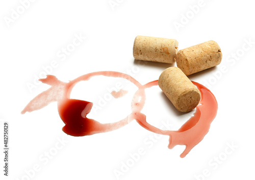 Spilled wine and corks on white background