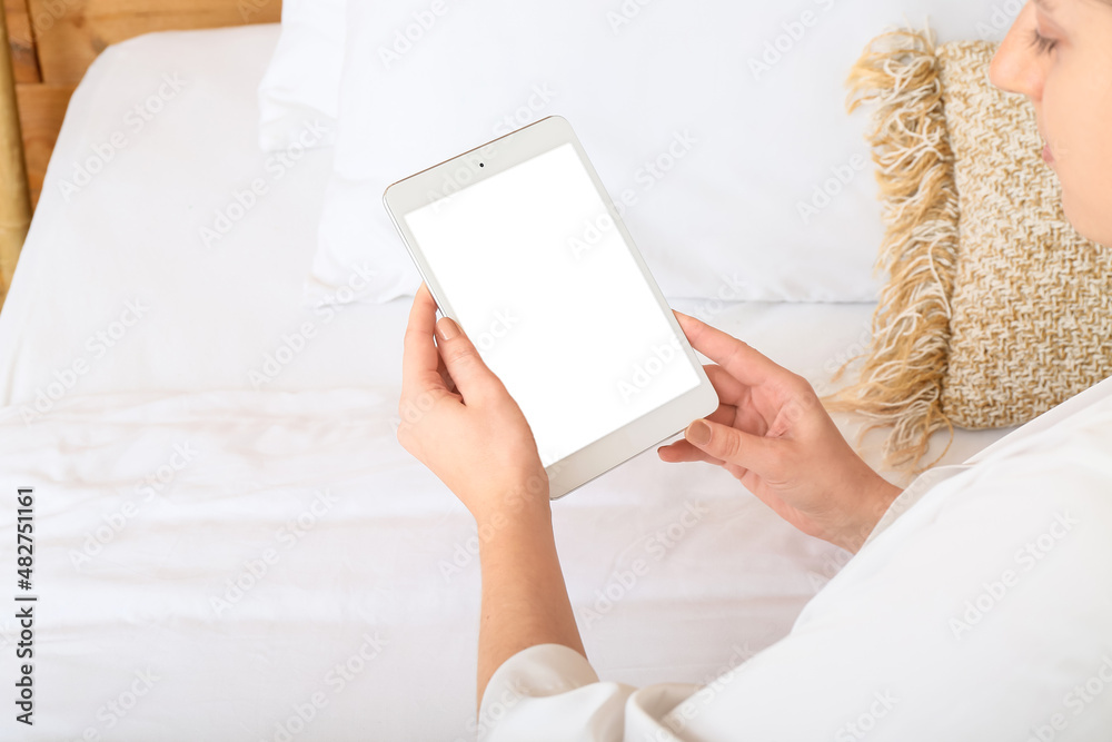 Woman holding tablet computer with blank screen on bed at home, closeup Woman holding tablet computer with blank screen on bed at home, closeup