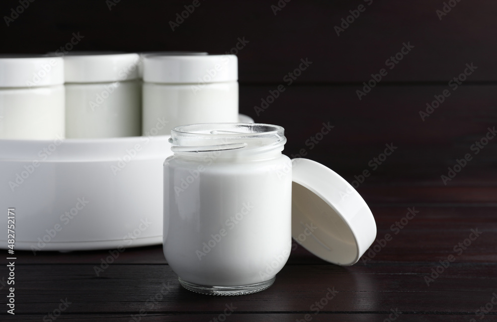 Glass jar with tasty yogurt on wooden table Glass jar with tasty yogurt on wooden table