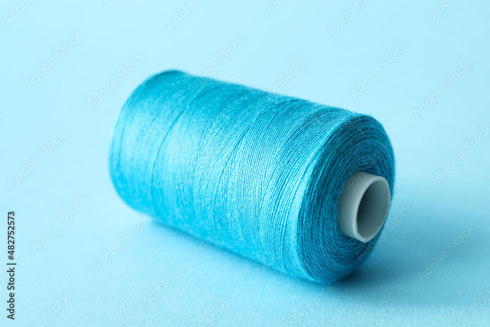 Blue sewing thread spool on color background Blue sewing thread spool on color background