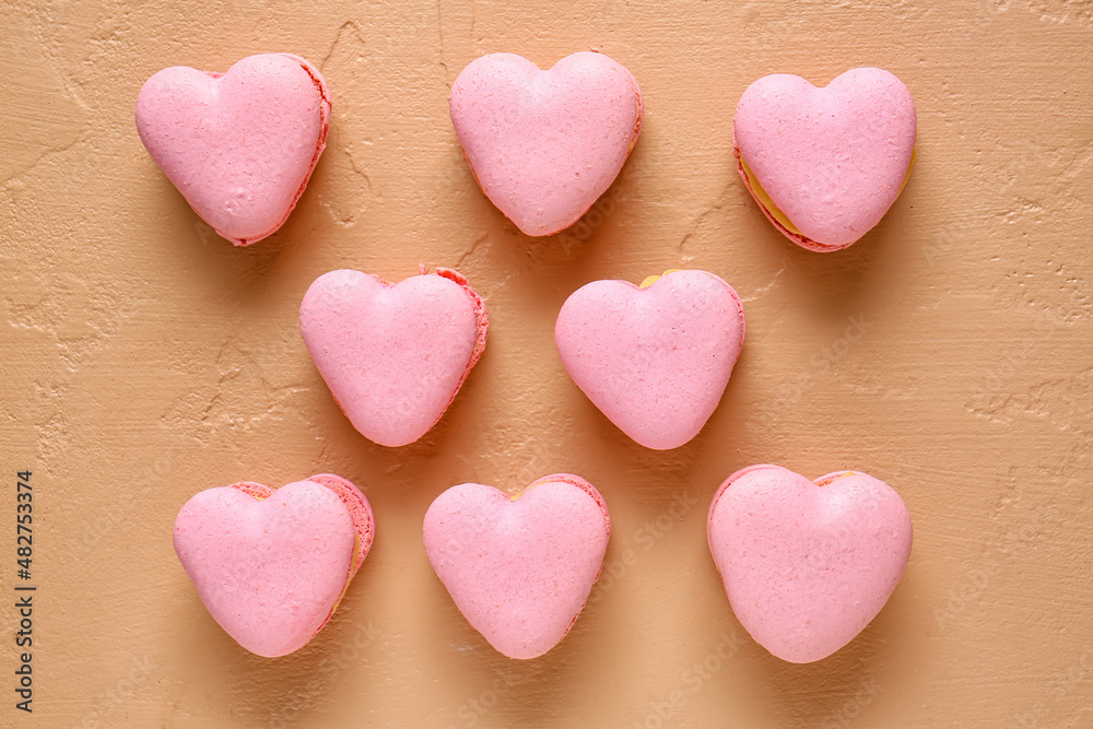 Tasty heart-shaped macaroons on beige background Tasty heart-shaped macaroons on beige background