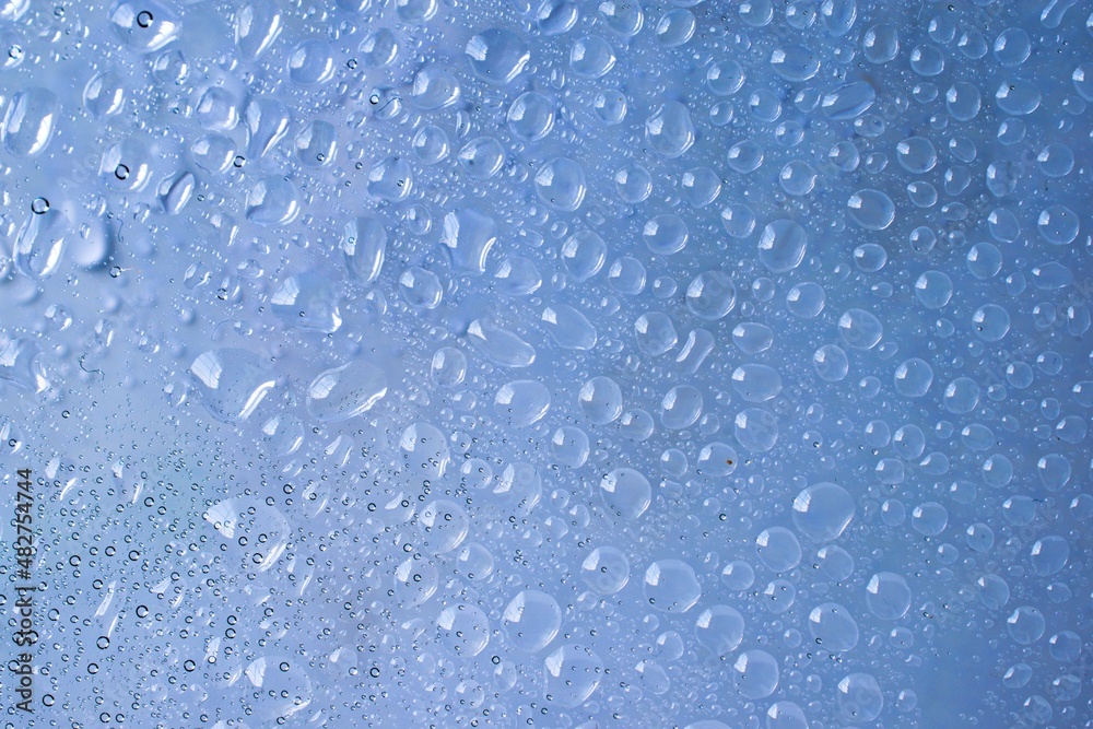 Water drop background on abstract blur blue clear glass surface Water drop background on abstract blur blue clear glass surface