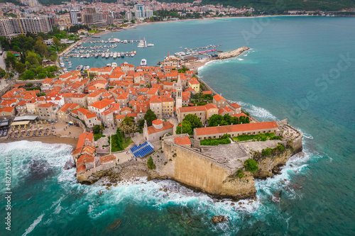 Aerial view of Budva old town with mighty sea waves, famous touristic place in Montenegro