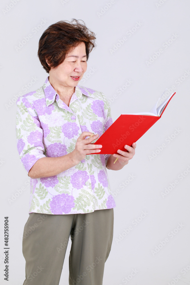 Elderly aunt, Senior Asian woman elderly teacher recording creative idea by writing a memo on note board on white background concept Elderly aunt, Senior Asian woman elderly teacher recording creative idea by writing a memo on note board on white background concept