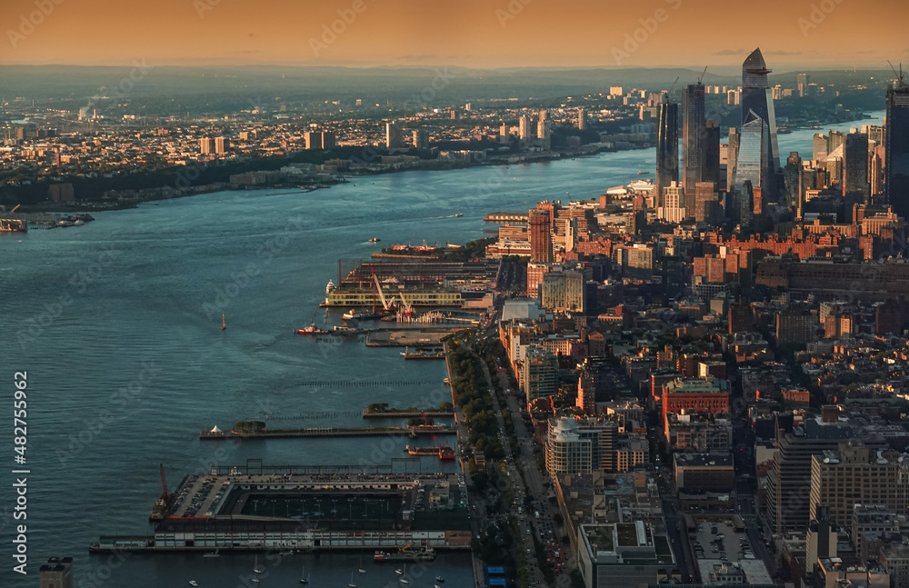 Obraz premium Sunset in New York, view from above. Amazing sun light over Manhattan and Hudson river during a sunset, images taken from the highest building in the city. Impressive architecture. Landmark of America