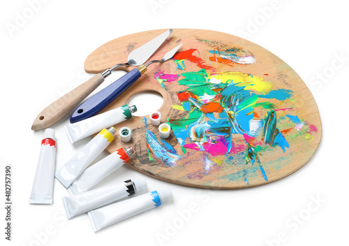 Palette with acrylic paints and spatulas on white background. Artist equipment