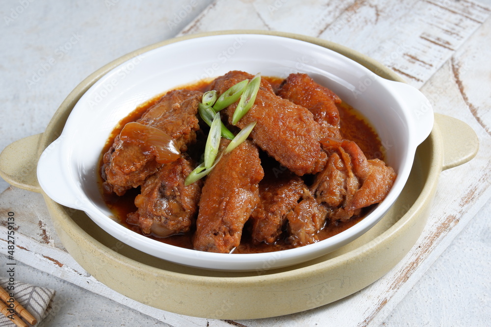 fried chicken butter or called ayam goreng mentega, in white plate. Indonesian cuisine.