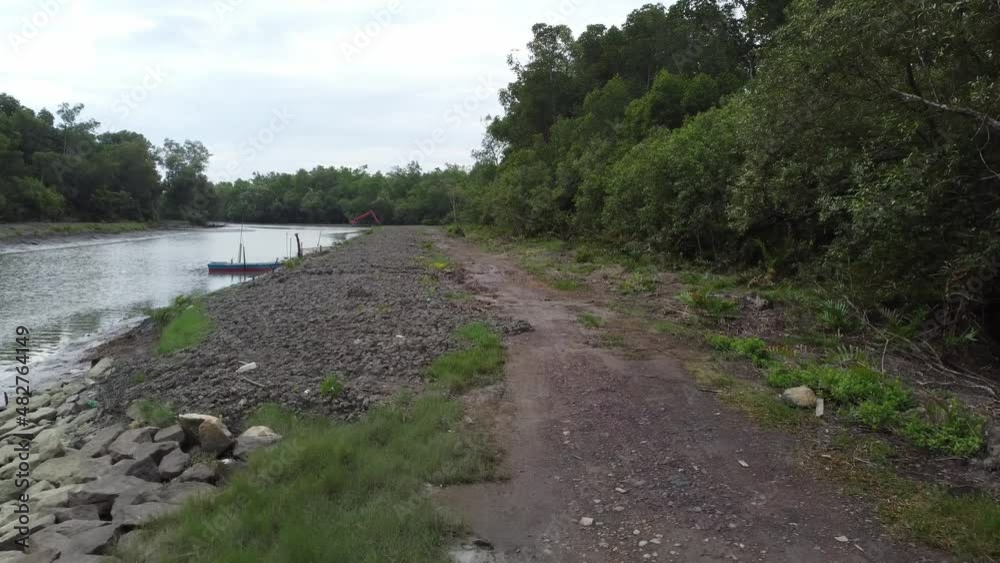 Move along the rural path toward the excavator working at river Move along the rural path toward the excavator working at river