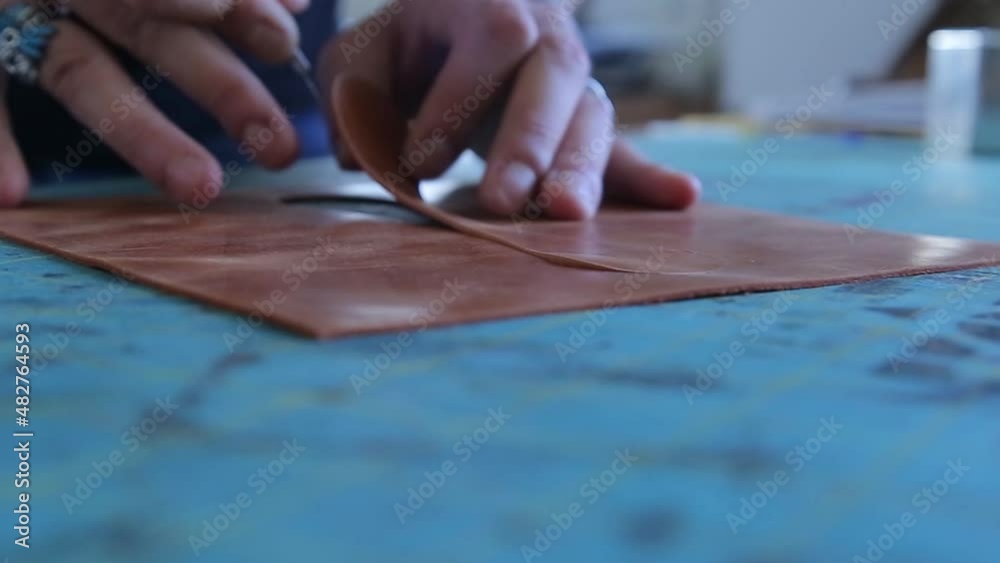 The cut brown leather is removed to turn it into a handmade leather bag. The cut brown leather is removed to turn it into a handmade leather bag.