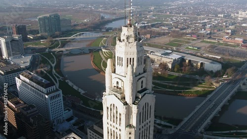 Aerial view in front of the sunlit Leveque Tower, in Columbus - descending, tilt, drone shot photo