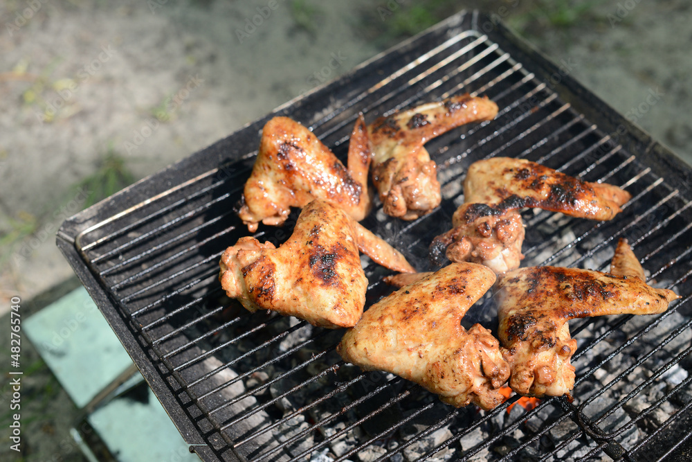 Grilled chicken wings, BARBECUE Chicken in hot sauce grilled on coals on the grill outdoors, picnic in the garden or in the backyard. Chicken BBQ