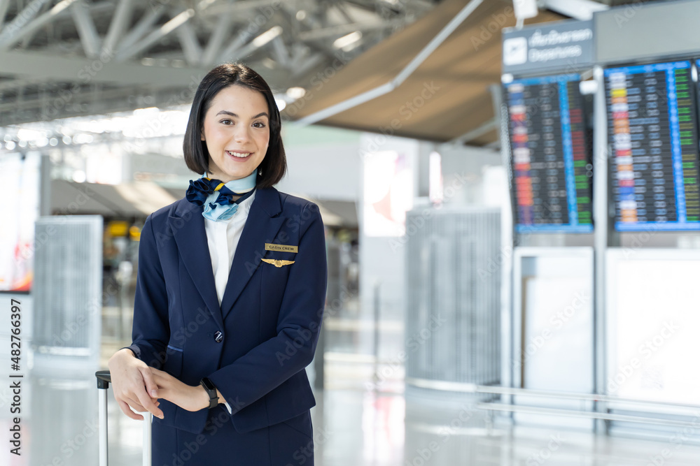 Portrait of Caucasian flight attendant standing in airport terminal. Portrait of Caucasian flight attendant standing in airport terminal.