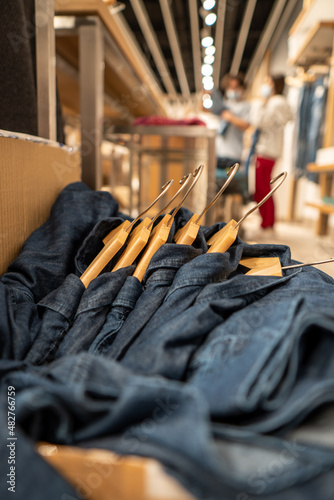 Denim shirts hanging inside a cardboard box in a clothing store