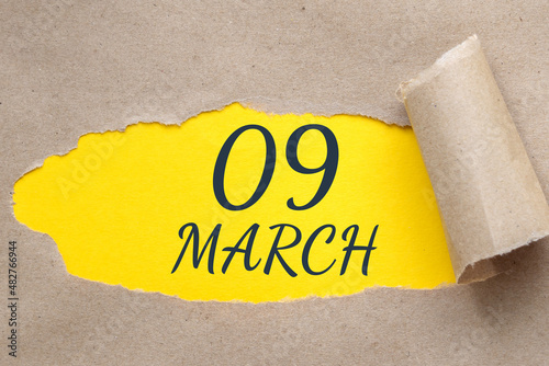 march 09. 09th day of the month, calendar date. Hole in paper with edges torn off. Yellow background is visible through ragged hole.Spring month, day of the year concept photo