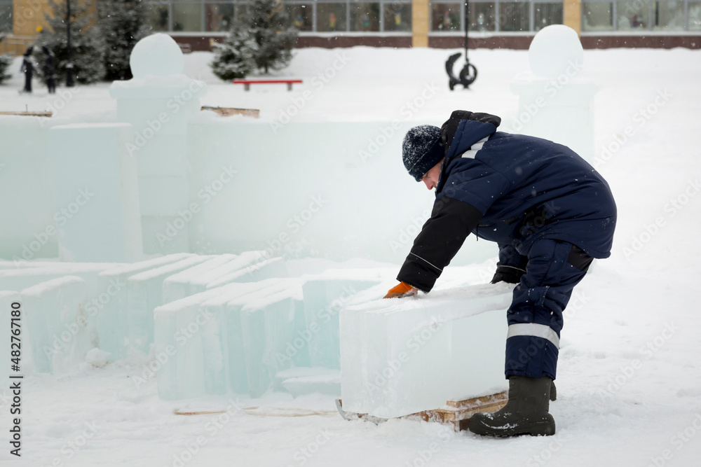 A worker loads ice blocks onto a sled A worker loads ice blocks onto a sled