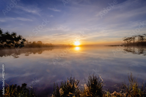 Fototapeta Naklejka Na Ścianę i Meble -  Sunrise over water with foggy at Wang Kwang Reservoir Phu Kradueng National Park, Loei province, Thailand