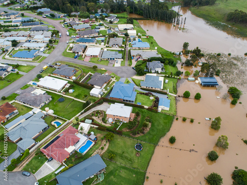 Backyards of homes full of brown floodwater from river backflow photo