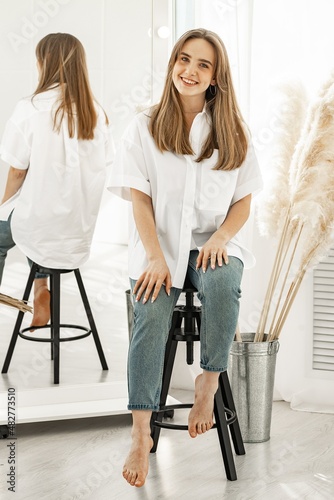 Portrait of a pretty cute young girl. Beautiful positive girl in a white cotton shirt. Vertical shot