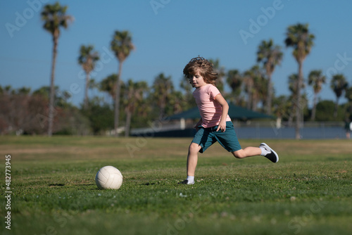 Soccer kid. Kids play football on outdoor stadium field. Little boy kicking ball. School football sports club. Training for sport children. Kids play soccer game.