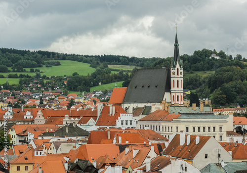 houses with red roofs and the spire of a small Gothic church in a small European town or village