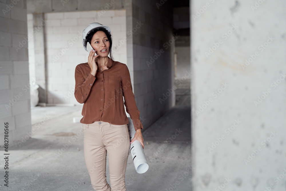 Female mature caucasian engineer walking on construction site Female mature caucasian engineer walking on construction site