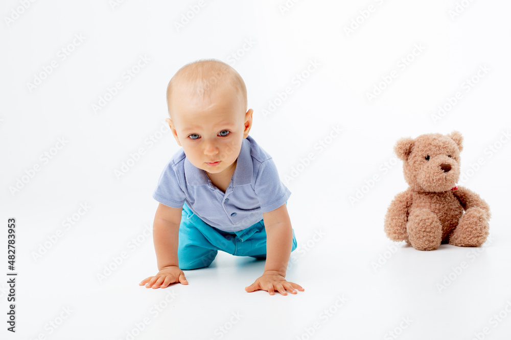 baby boy crawling , crying on a white background with teddy bear baby boy crawling , crying on a white background with teddy bear