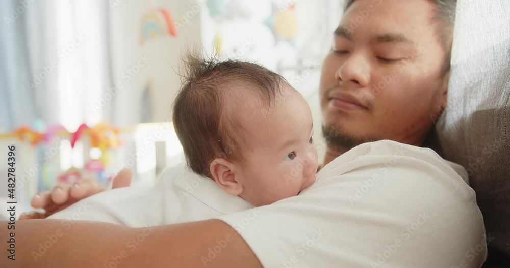 Happiness family Asian father enjoying resting time together caring cuddling embraces with adorable newborn baby girl lying on bed at home in the morning, Fatherhood family love relationship concept Happiness family Asian father enjoying resting time together caring cuddling embraces with adorable newborn baby girl lying on bed at home in the morning, Fatherhood family love relationship concept