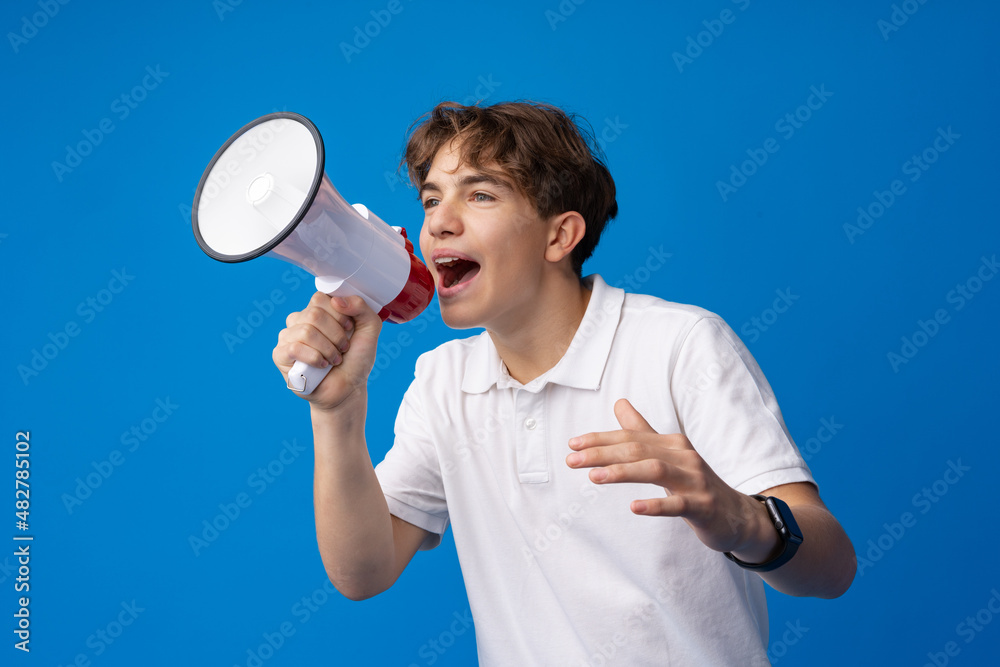 Teen boy making loud announcement against blue background. Teen boy making loud announcement against blue background.