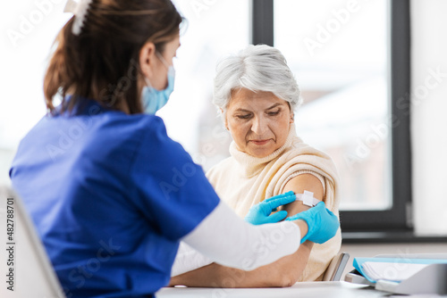 Принти на полотні medicine, health and vaccination concept - doctor or nurse applying medical patc