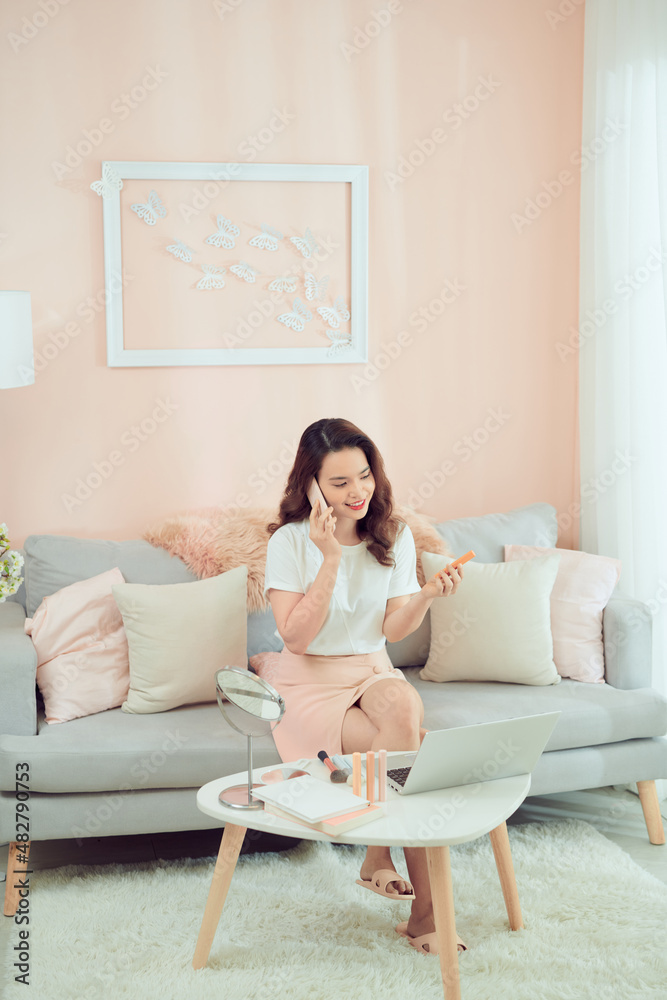 woman applying her makeup decorative cosmetics and talking on phone. woman applying her makeup decorative cosmetics and talking on phone.