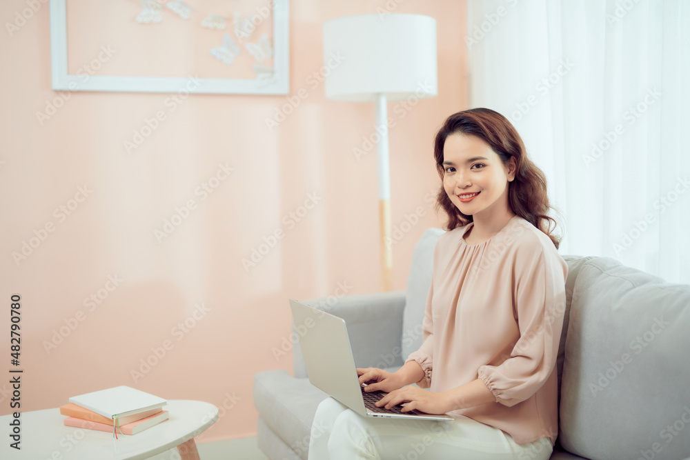 Satisfied woman relaxing on comfortable couch, using laptop at home Satisfied woman relaxing on comfortable couch, using laptop at home