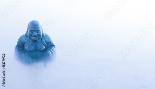 Fototapeta Naklejka Na Ścianę i Meble -  Buddha sitting on a rock surrounded by natural mist. Buddhist background 