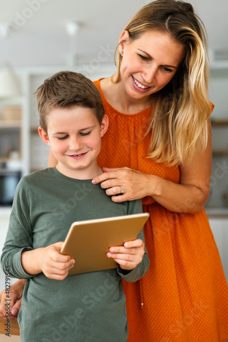 Mother and child using digital tablet for e-learning. Education home digital device kid concept.