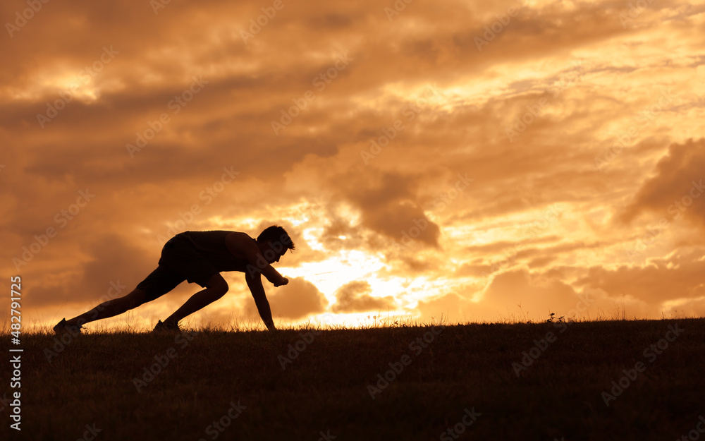silhouette of male runner tying his sprint 