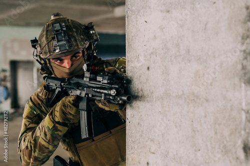 Принти на полотні Special forces operator wearing Multicam uniform and his assault rifle HK 416 while practicing CQB combat training in the abandoned building