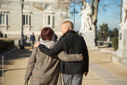 senior caucasian man and woman couple walking arm in arm