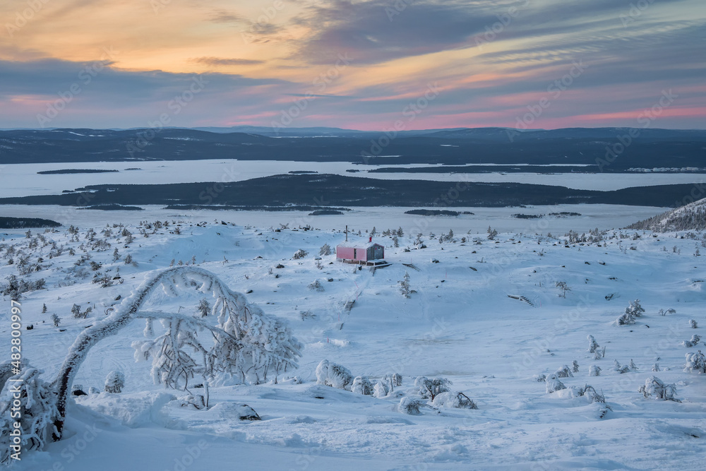 Winter time. Cabins in winter. Dubldom on the mountain Volodyanaya Kandalaksha, Murmansk region in Russia.